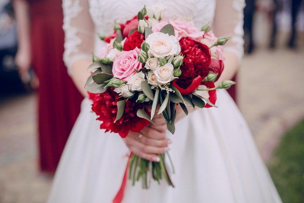 close-up-hands-holding-wedding-bouquet_1157-319-freepik